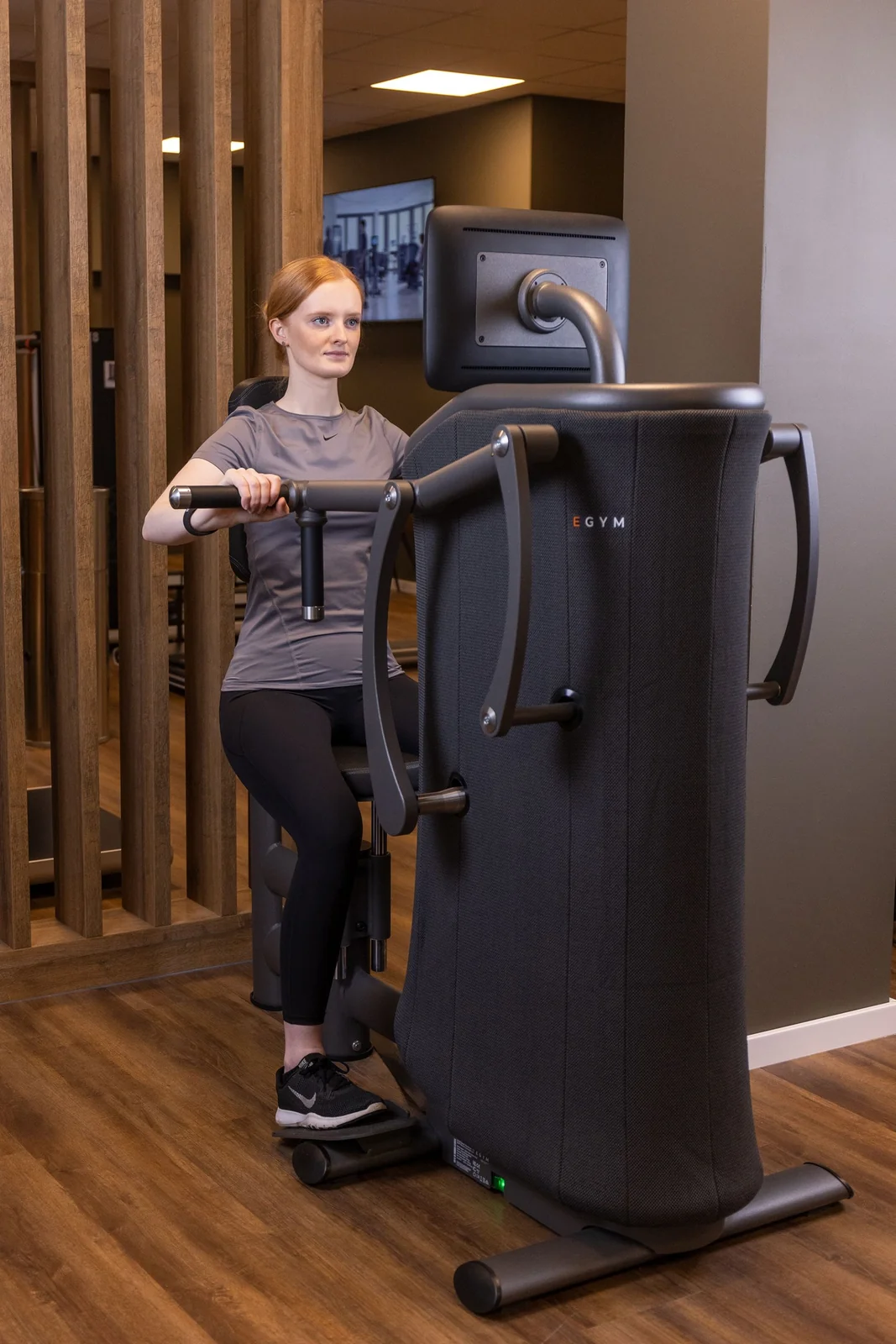Trainer betreut eine Frau beim Krafttraining an einem Gerät in der Körperwerkstatt Neuenkirchen