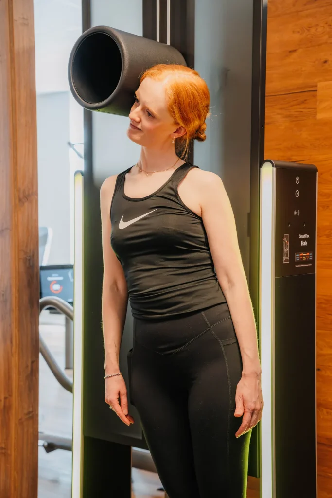 Frau steht an einem EGYM Smart Flex Trainingsgerät in der Körperwerkstatt Neuenkirchen.
